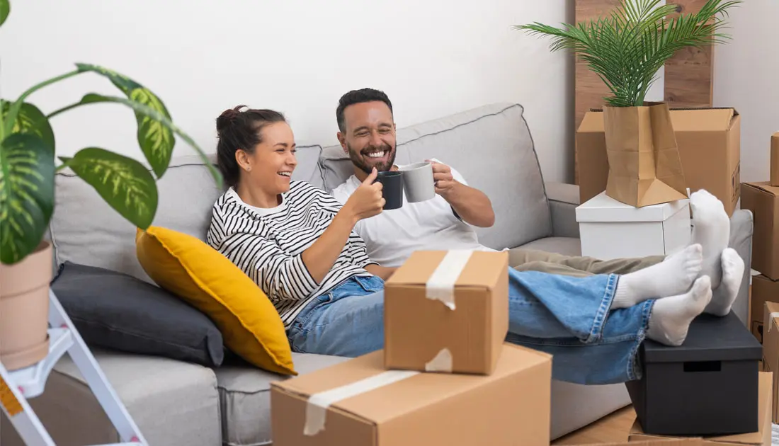 photo-of-man-and-woman-on-a-couch-celebrating-after-moving