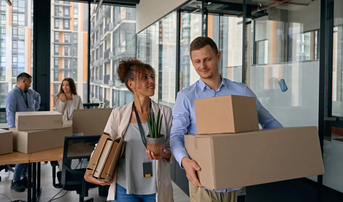 photo-of-woman-and-man-with-self-storage-boxes-at-the-office-talking-to-each-other
