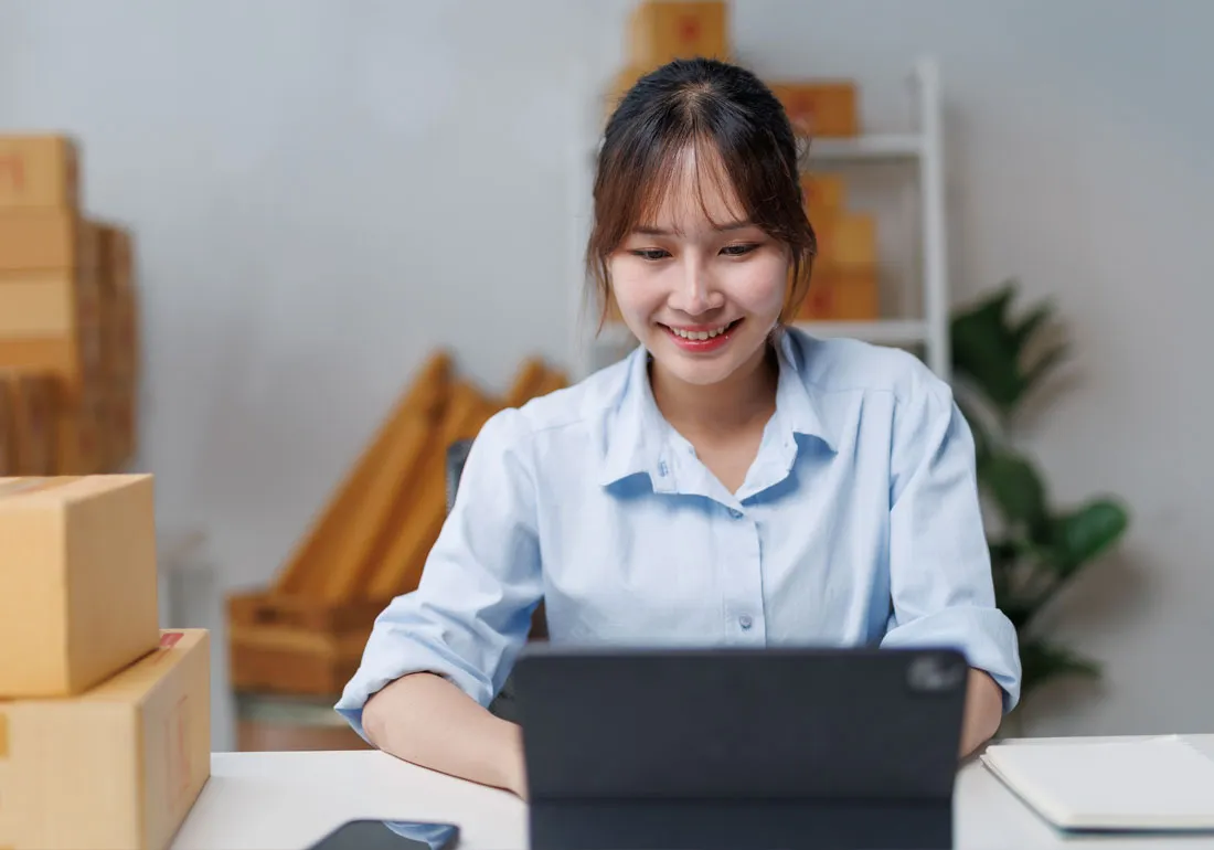 picture-of-a-woman-working-on-a-laptop-conductiong-online-business-with-self-storage-boxes-behind