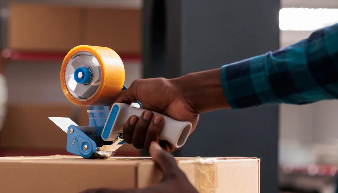 photo-of-a-person-taping-a-storage-box-with-a-tape